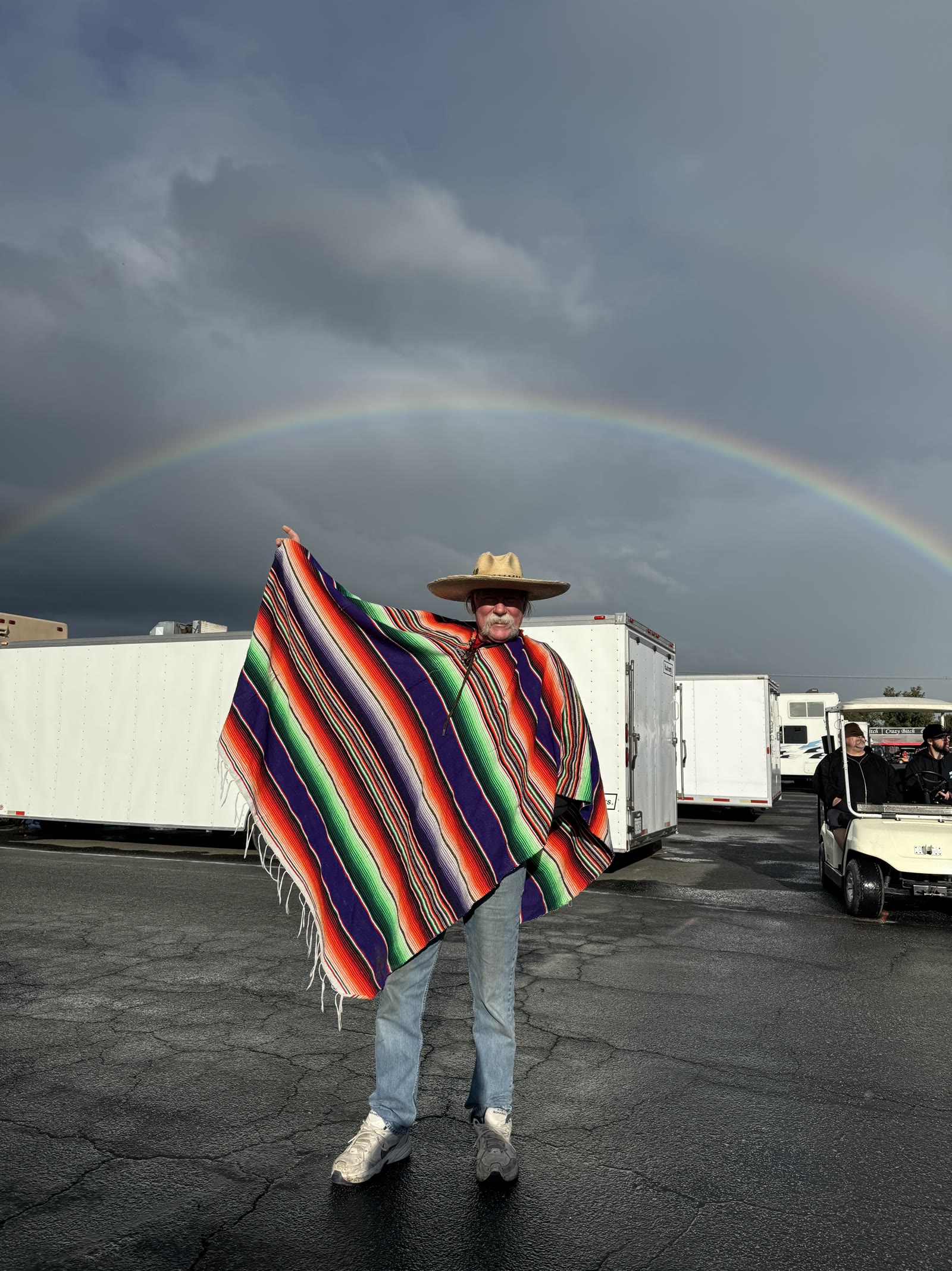 Donnie Ho beneath a rainbow in a colorful serape